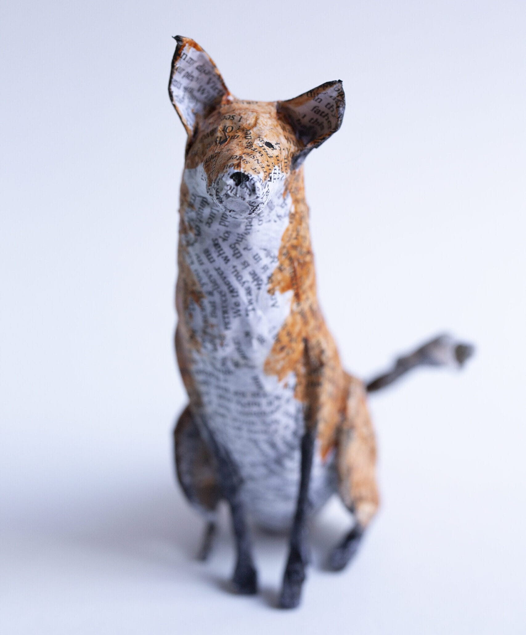 A small paper mache fox, made of newspaper