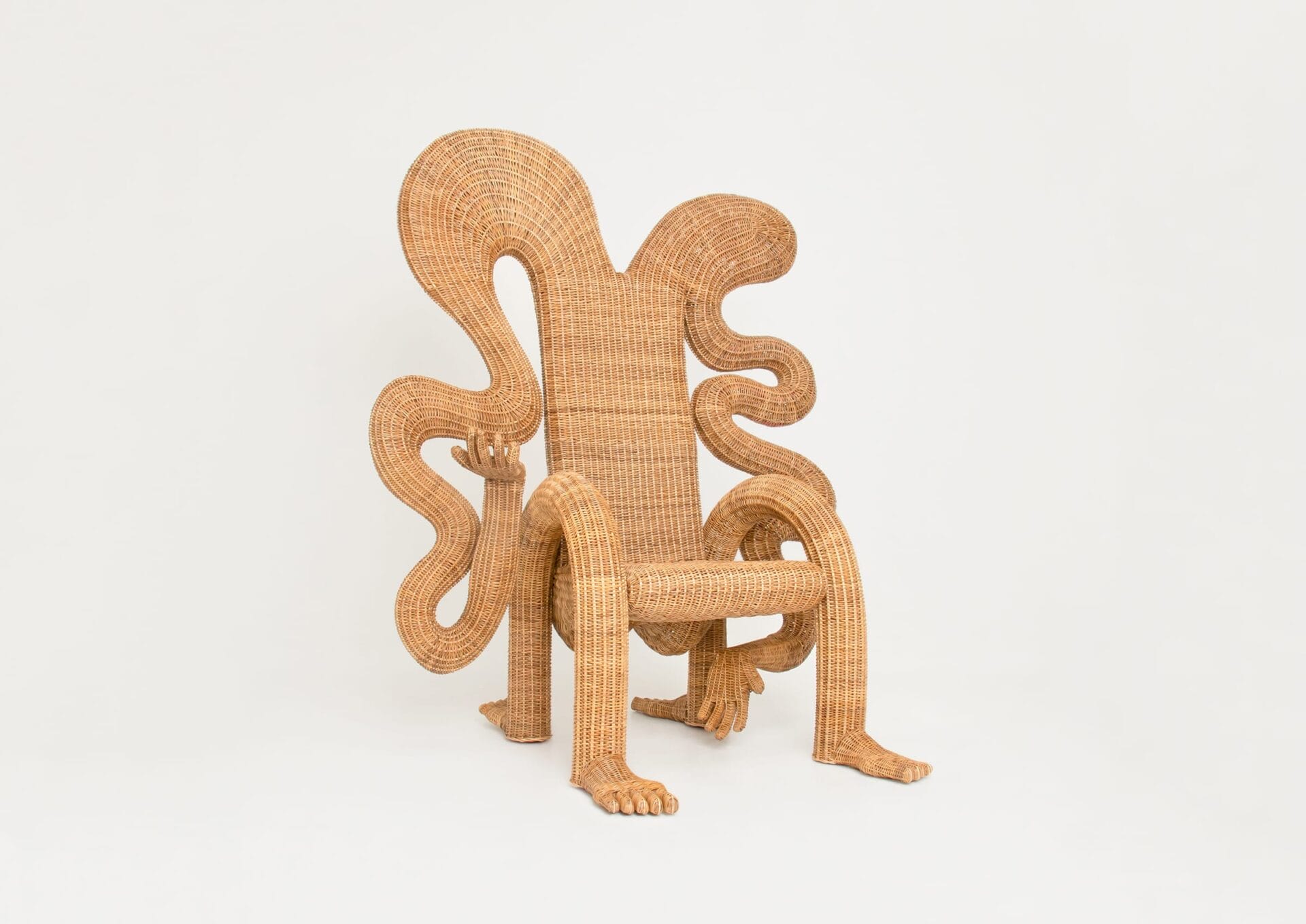 A wicker chair with wiggly arms, legs, and feet.