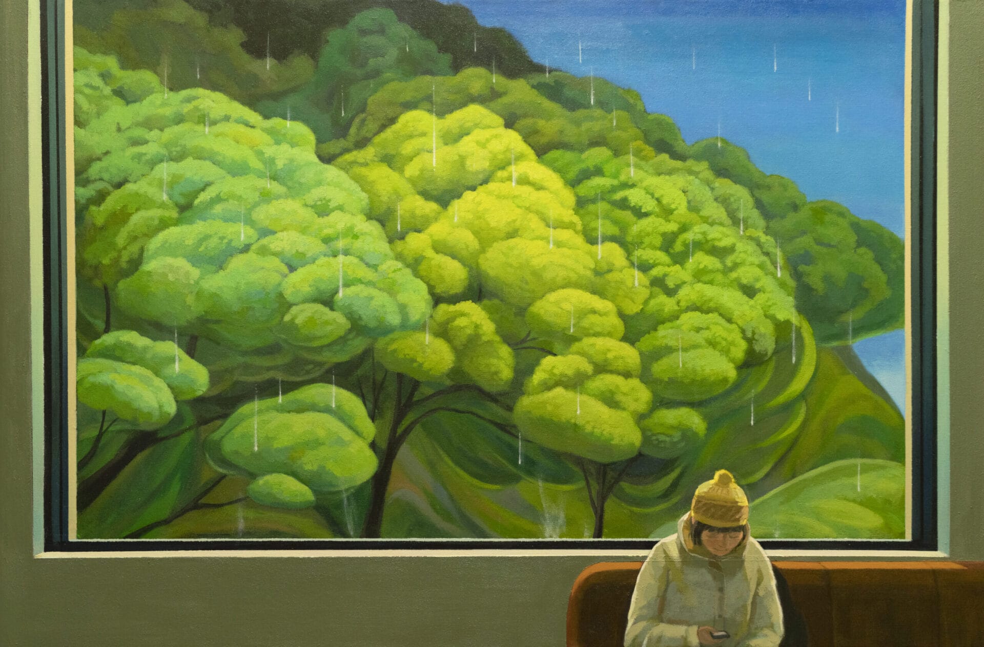 a very large window reveals vast trees as it rains. inside, a figure sits on a couch and looks down at their phone.