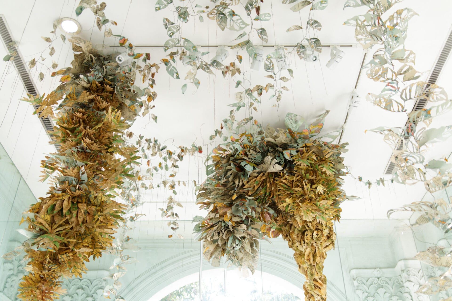 An installation of paper florals, descending from a ceiling.