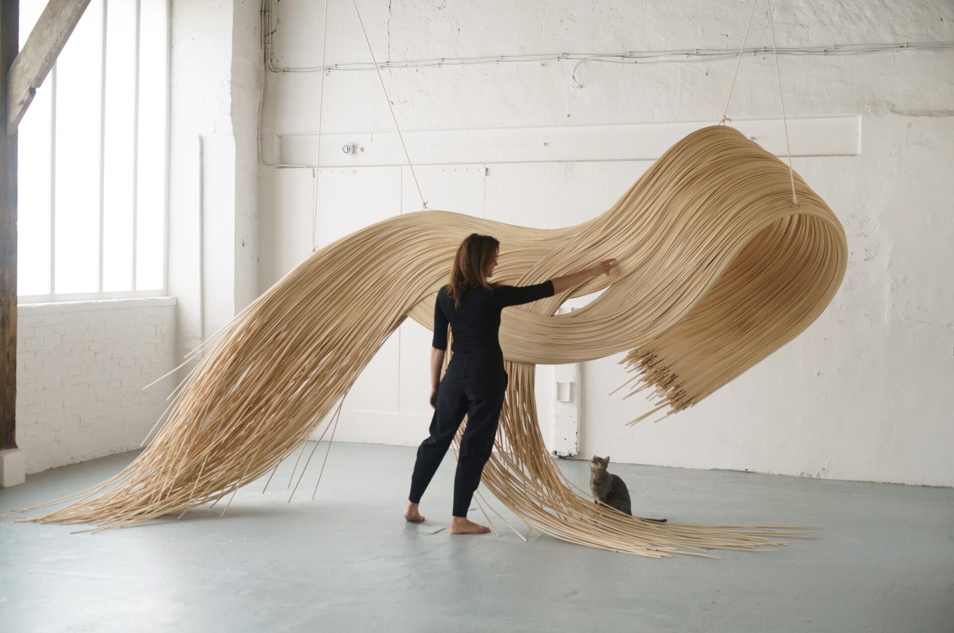 a cascading sculpture similarly formed to a wave, made from shaped rattan