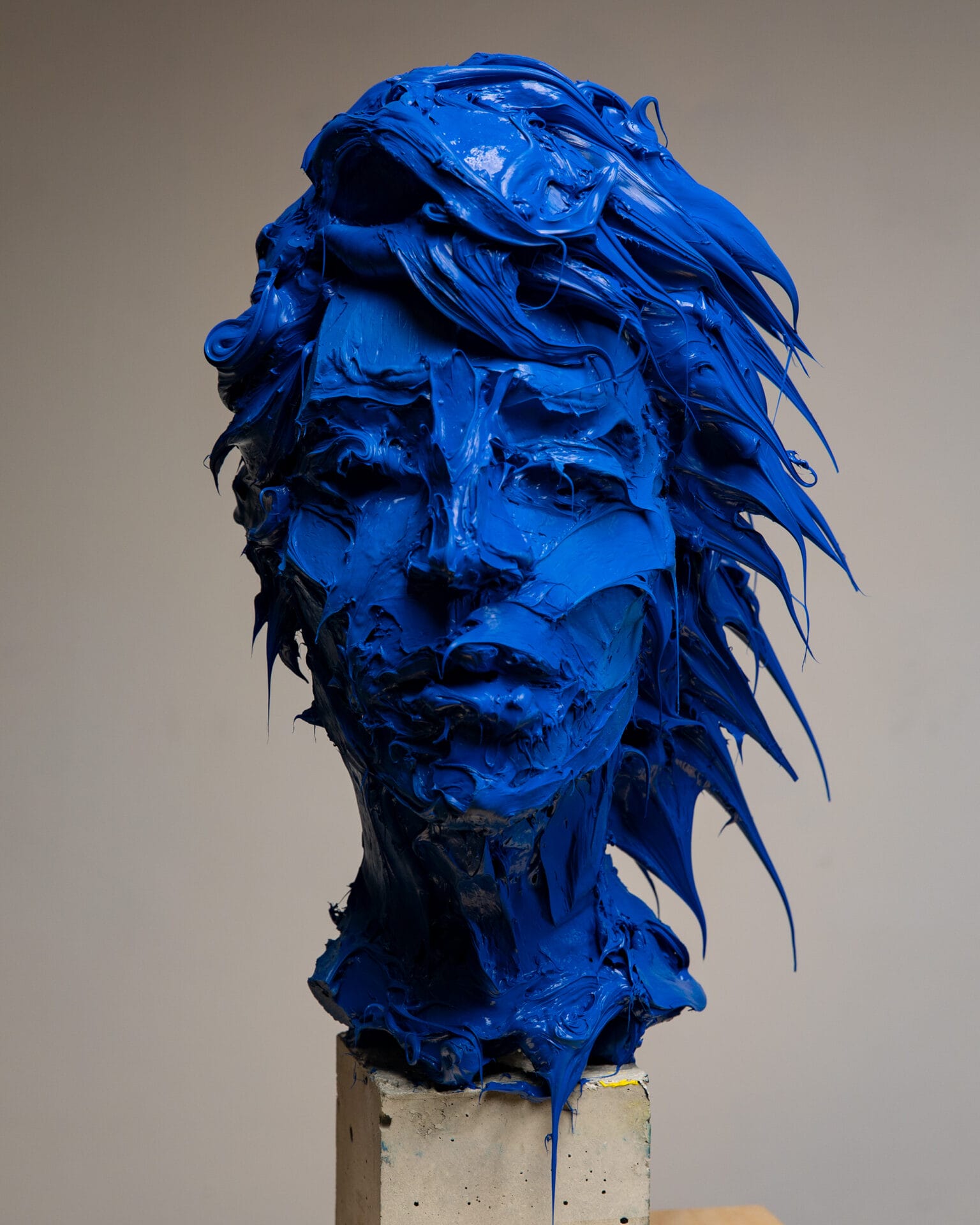 A bust fashioned from a gum-like substance, depicting a human head in hues of royal blue