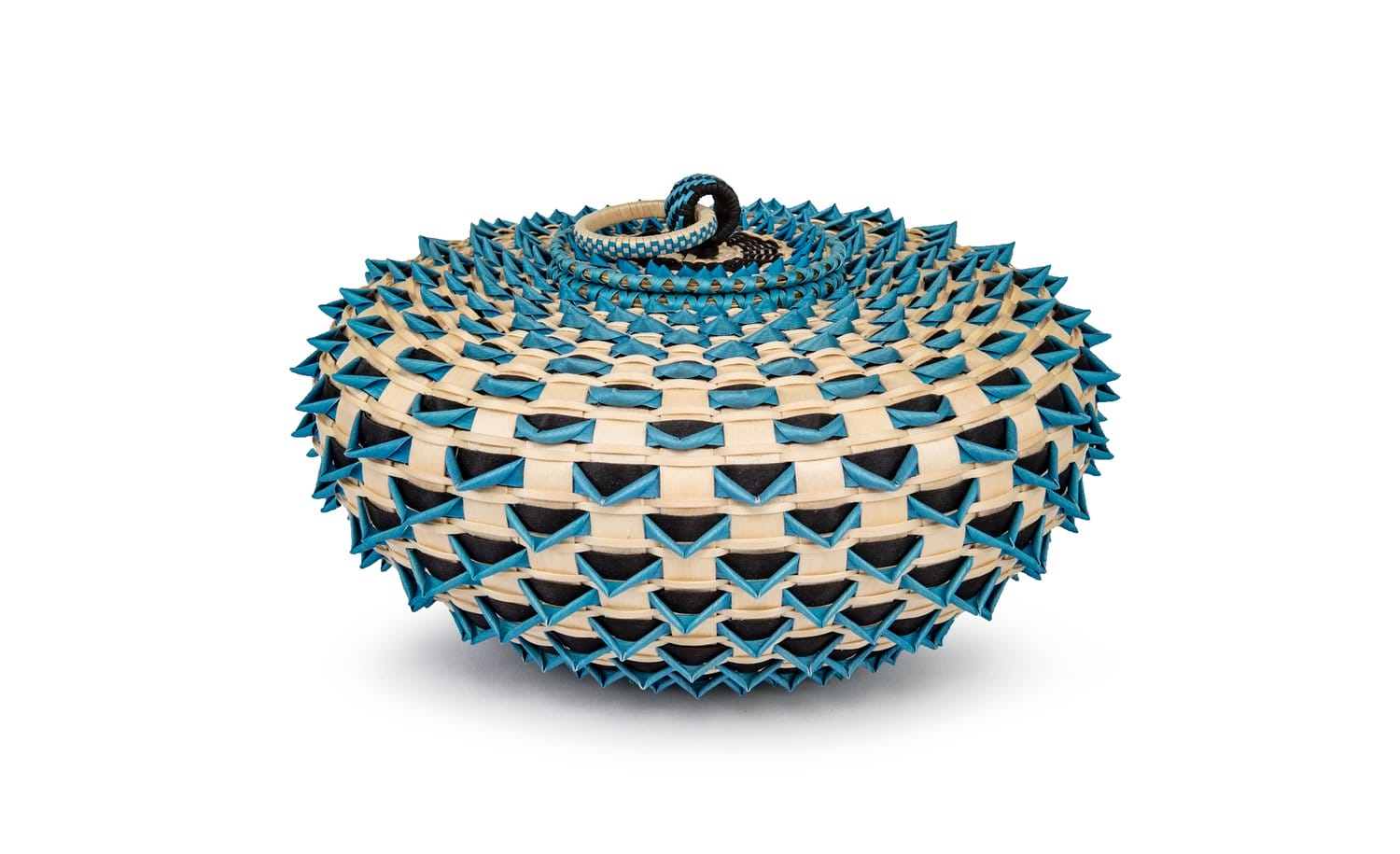 an "urchin" basket made from woven sweetgrass and dyed with bright blue and black to create geometric patterns