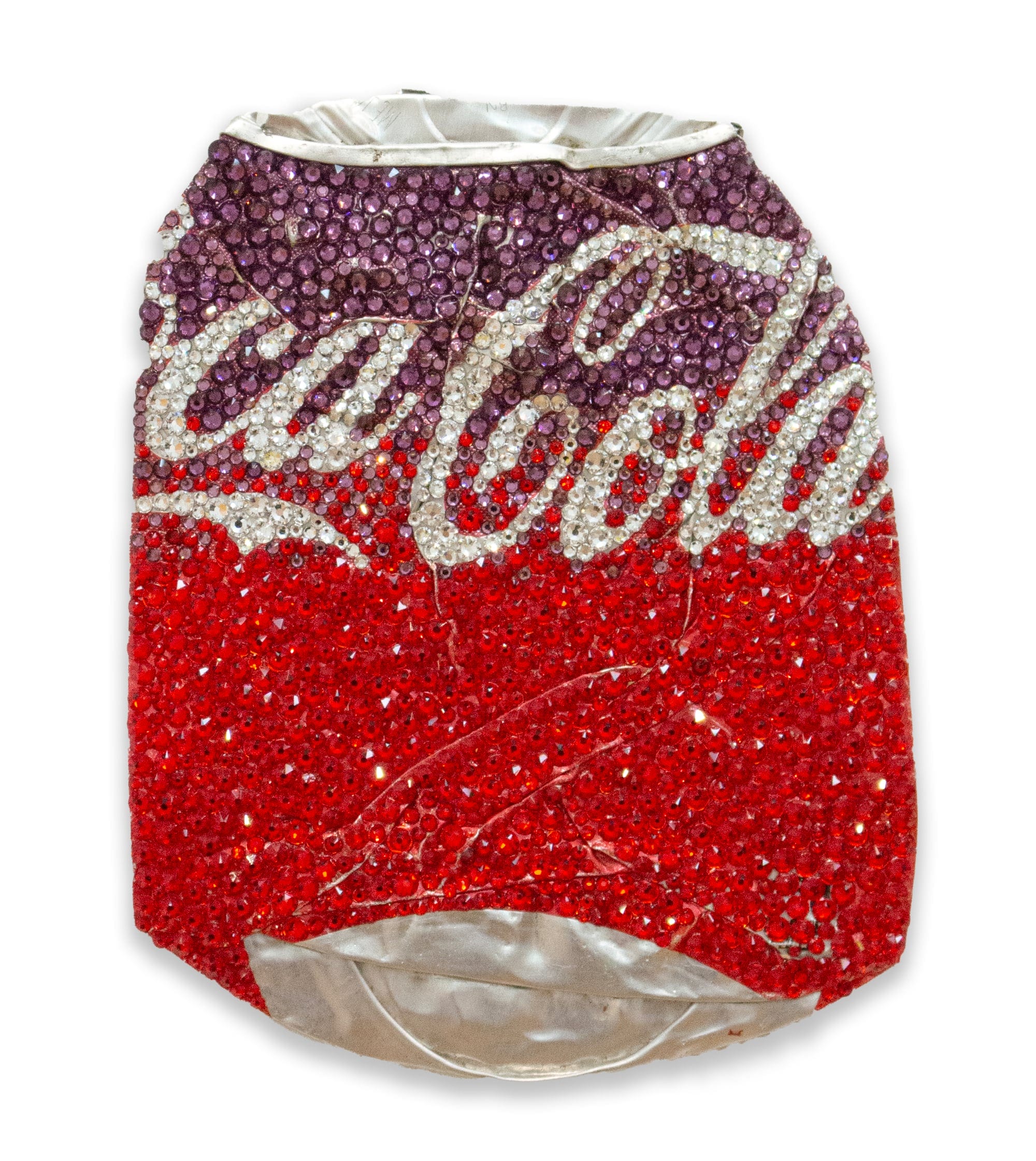 a flattened coca cola can covered in red and purple crystals