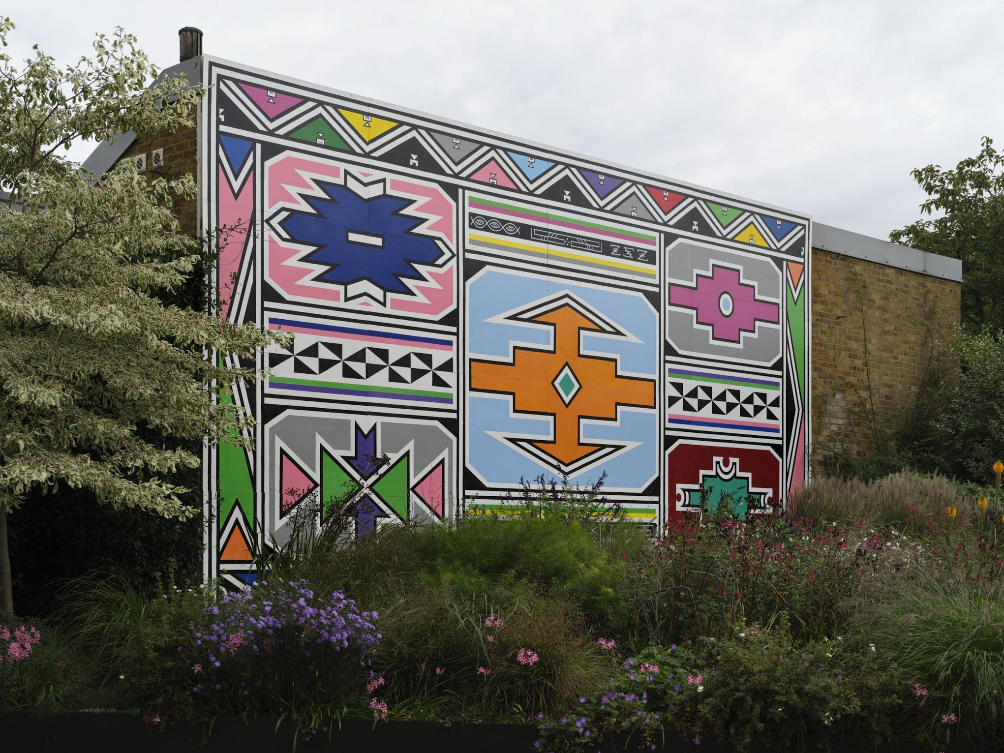 a mural depicting colorful Ndebele shapes and patterns outlined with a black border