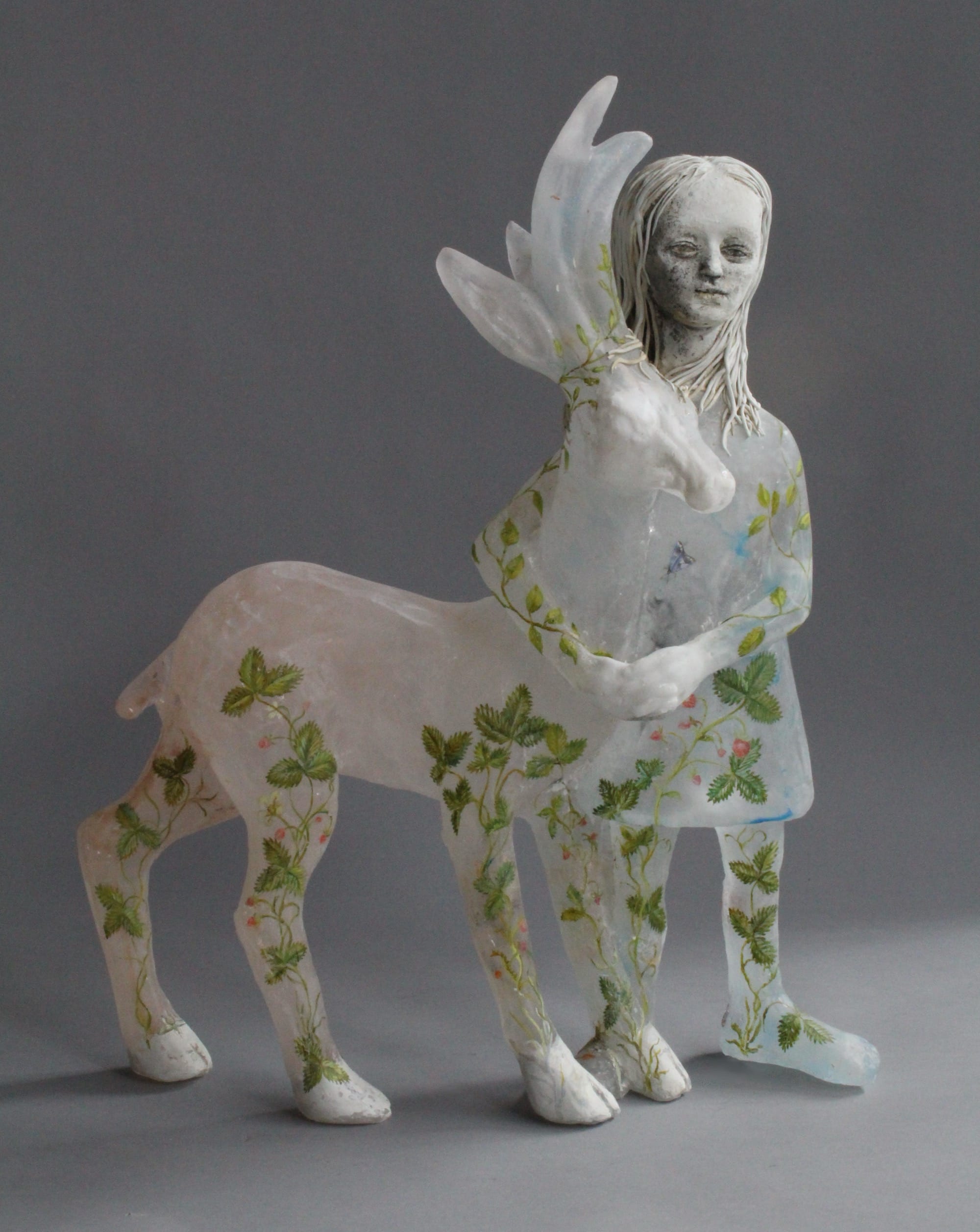 a glass and ceramic sculpture of a woman standing with a deer