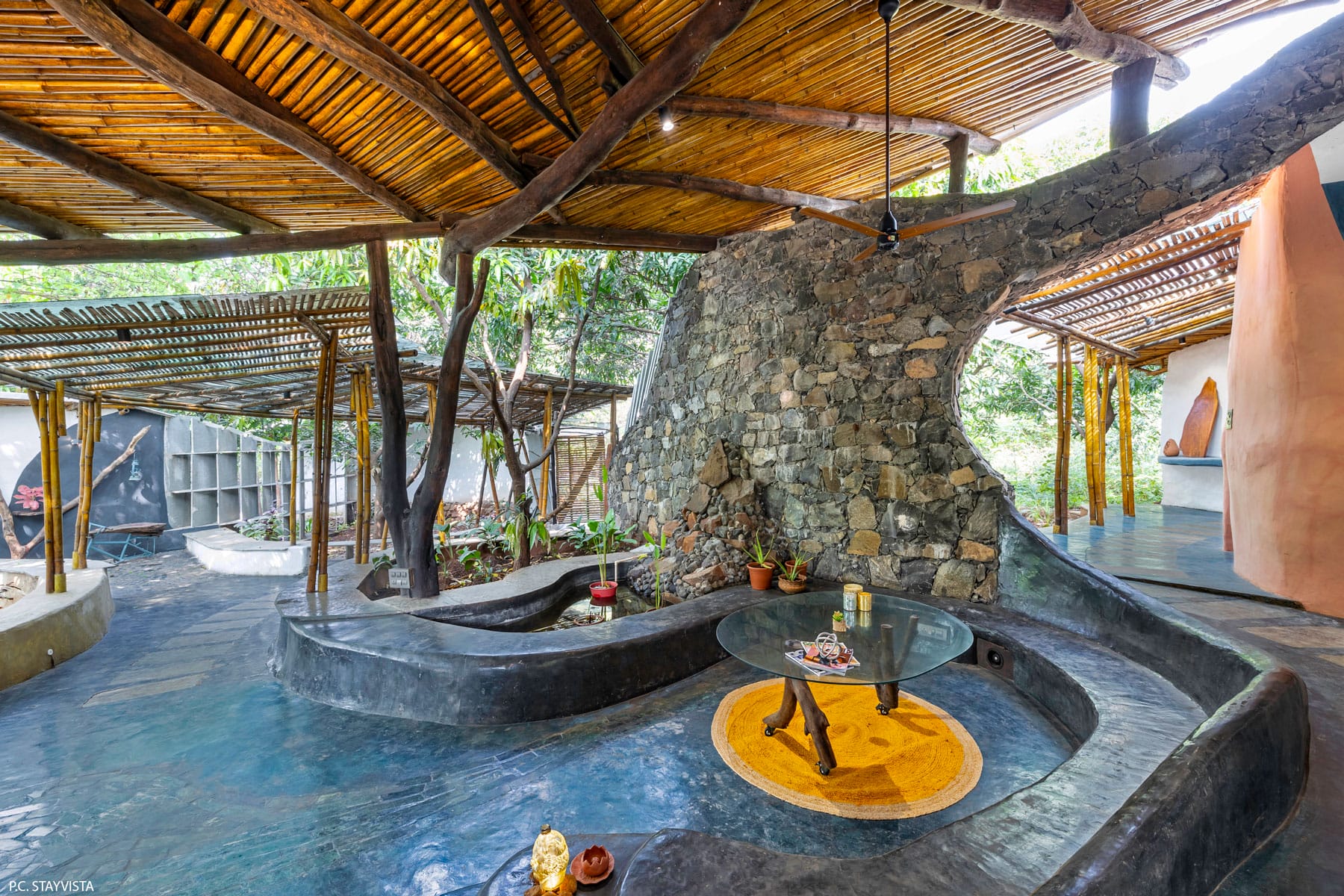 the interior of a biophilic residential design, with wood-beamed ceilings, organic walls, and earthy floors