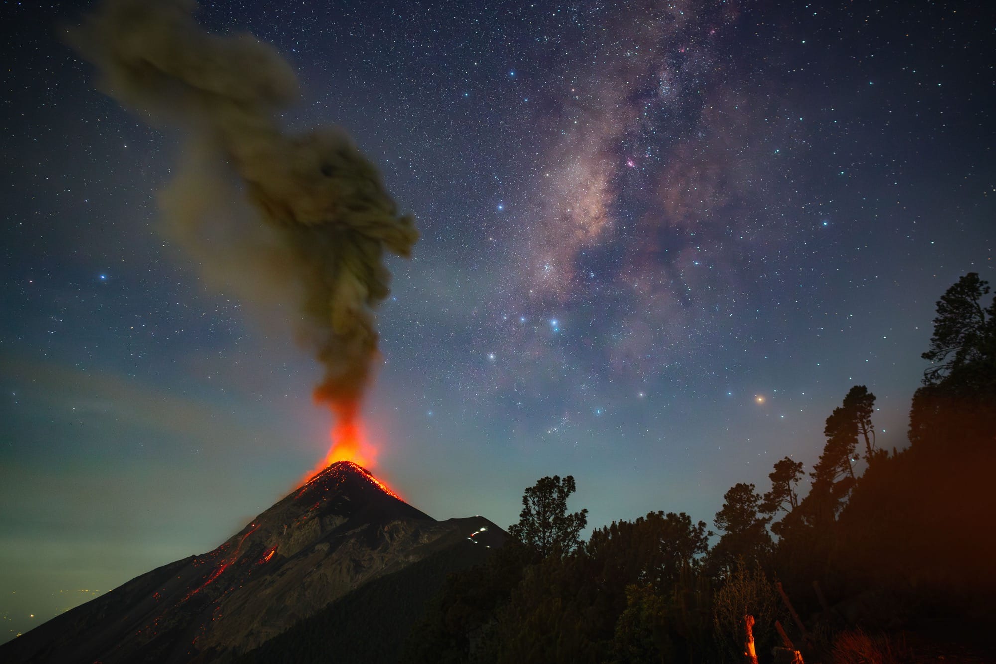 a volcano erupts beneath the milky way