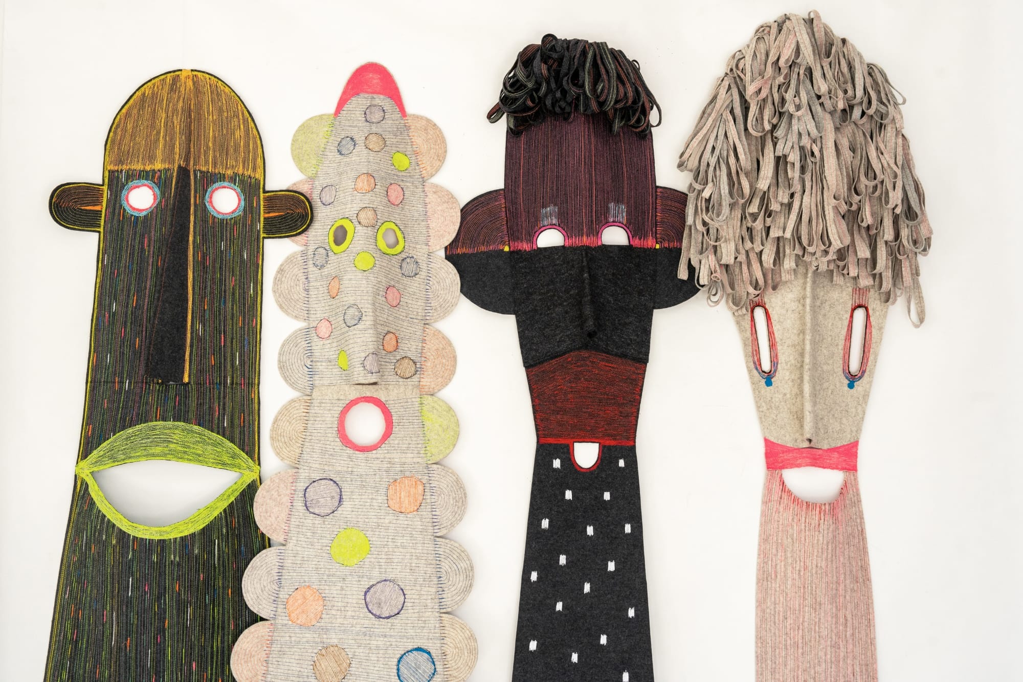 four figures made of colorful textiles