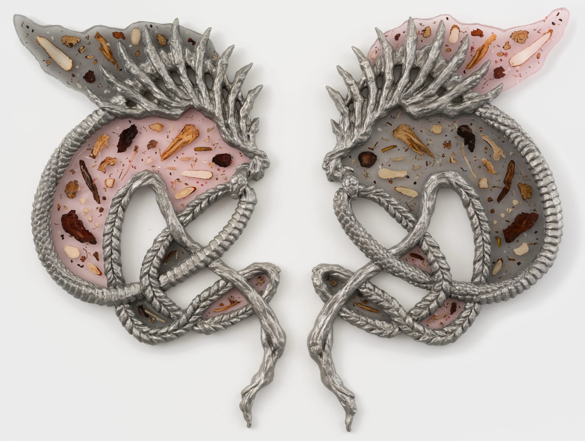 two creature like sculptures facing each other with translucent bodies of dried herbs