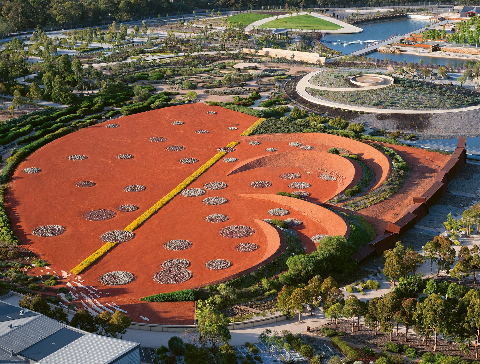 an aerial view of a contemporary garden with a large, terracotta-color sculptural platform