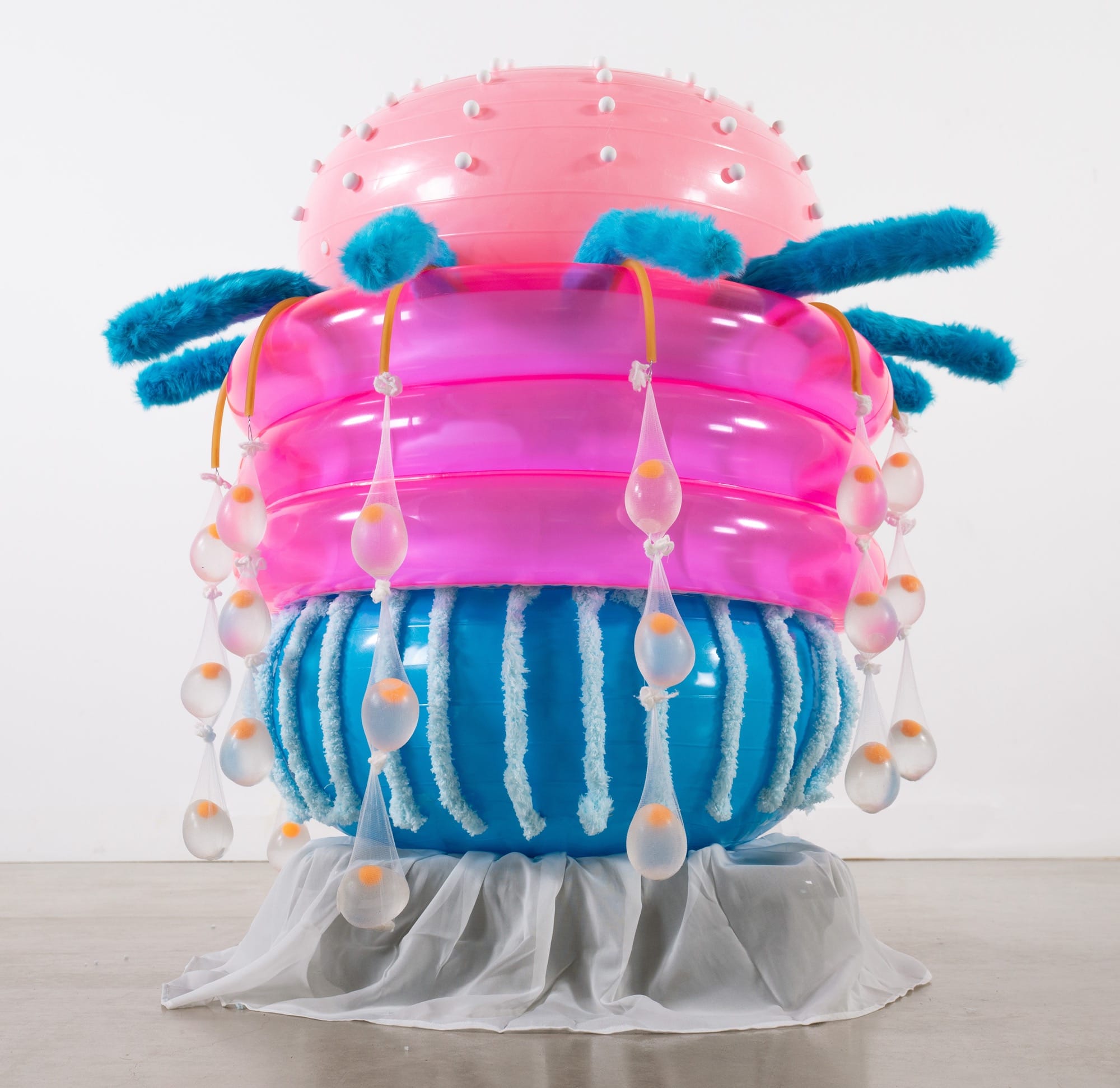 an abstract inflatable artwork that resembles a pink and blue, alien-like creature