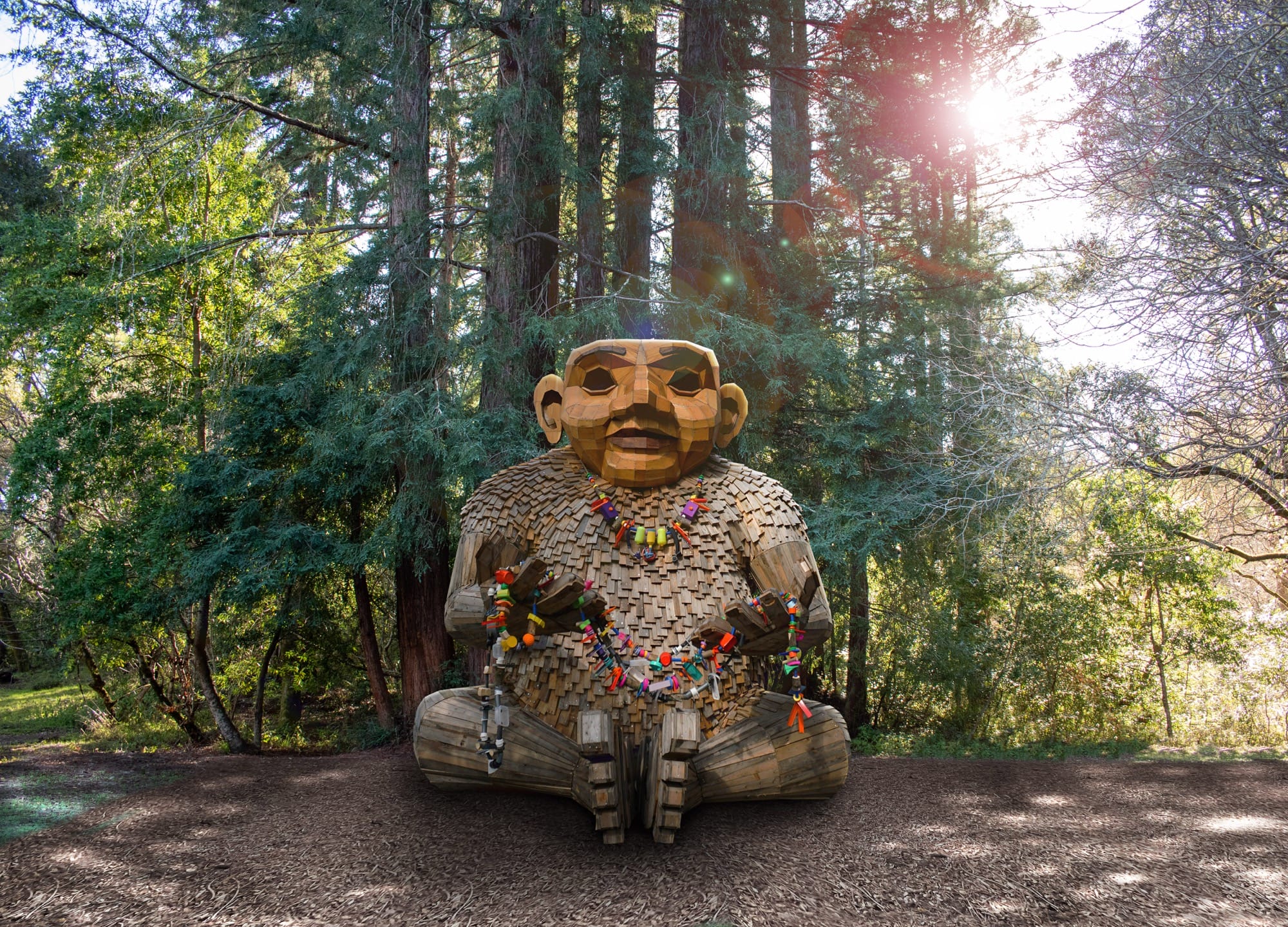 a giant wood troll seated in a woodland