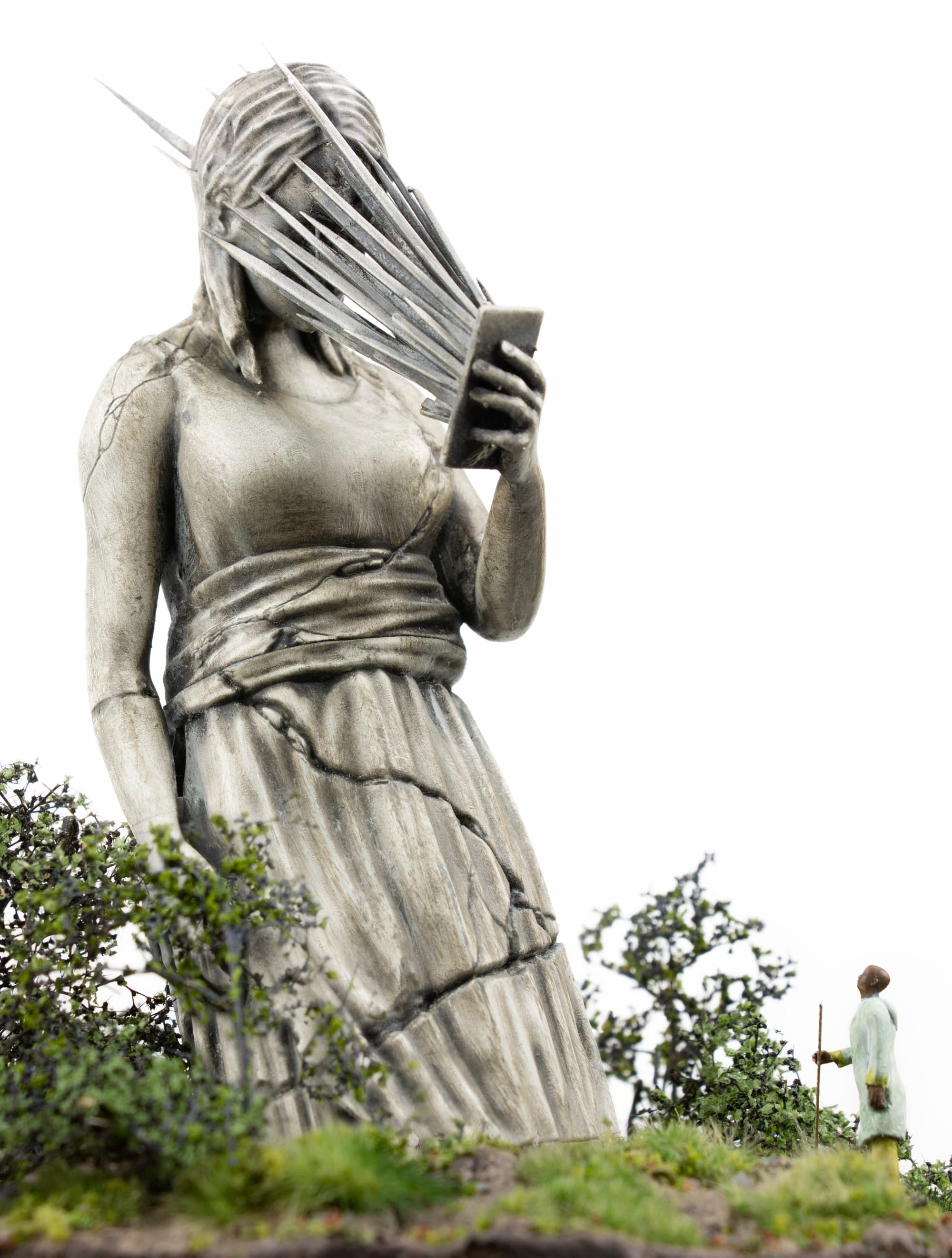 a miniature person looking at a figurative statue whose face melds into a phone