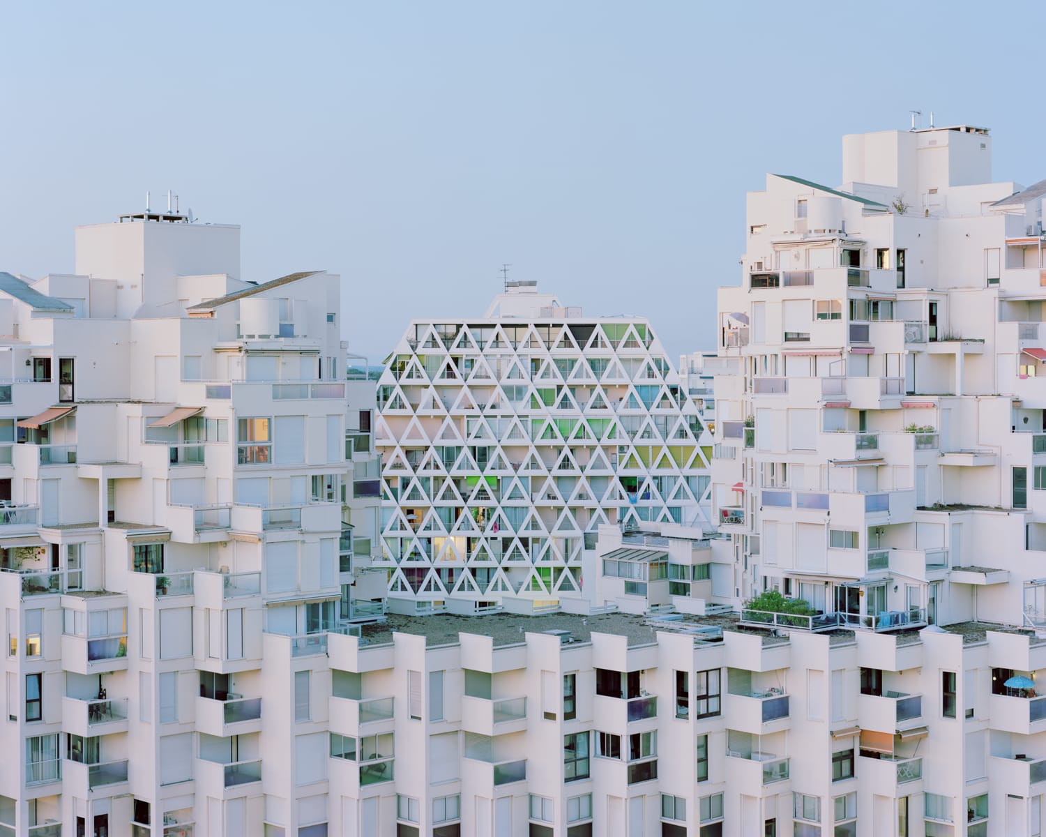 a modernist resort apartment complex in all-white against a blue sky