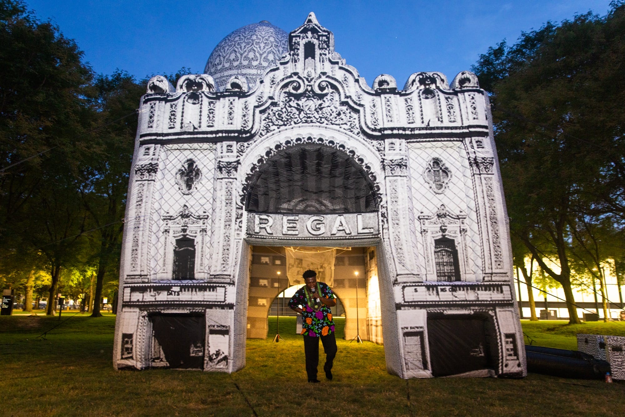 a person walks through a large, inflatable building with a sign that says "regal" across the entrance