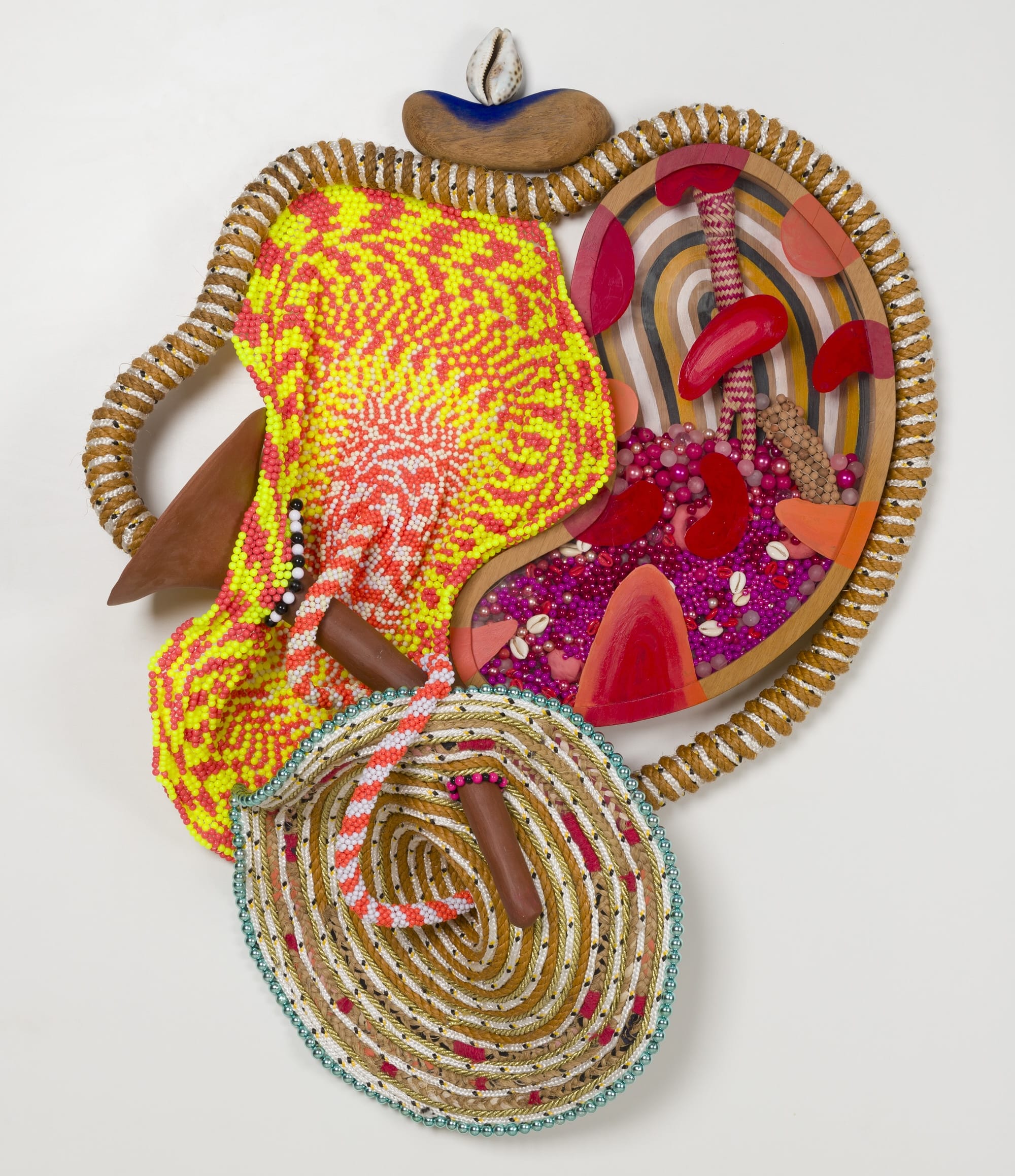 an abstract yellow and magenta sculpture by Maria Nepomuceno made of beads, resin, wood, and string