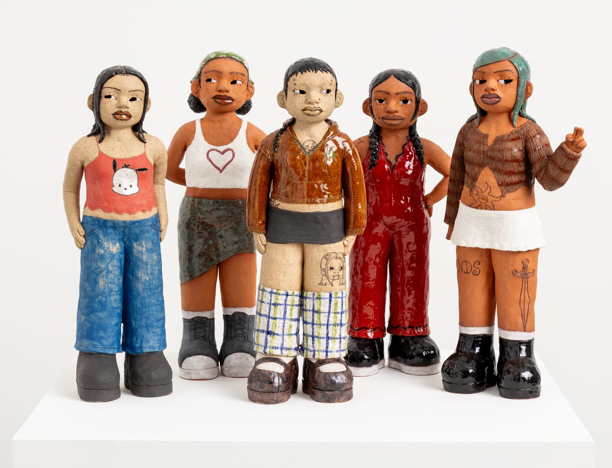 five standing ceramic sculptures, each is a girl with a distinct personality