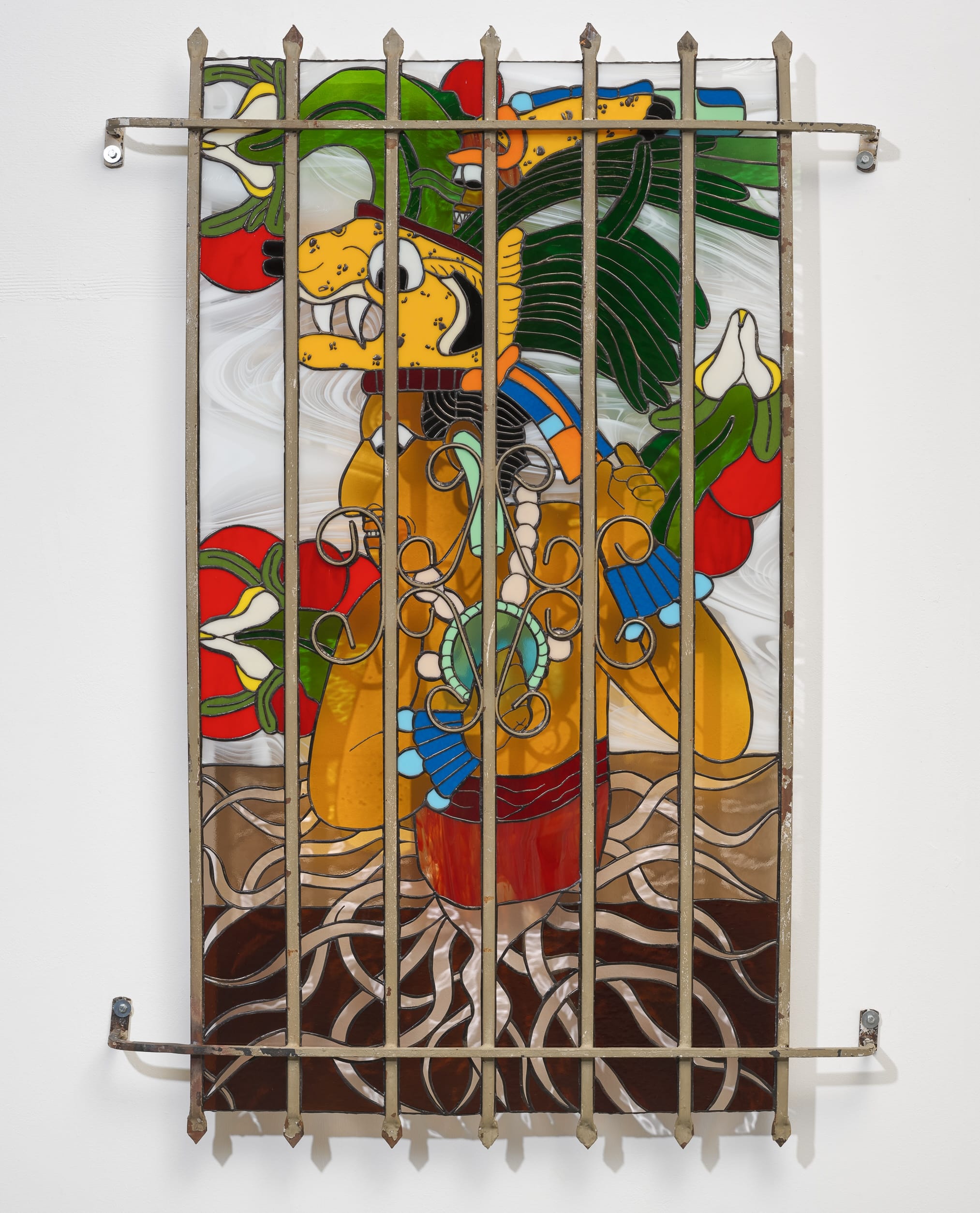 a wall sculpture by Timo Fahler made with stained glass and a metal grate depicting a Mesoamerican figure