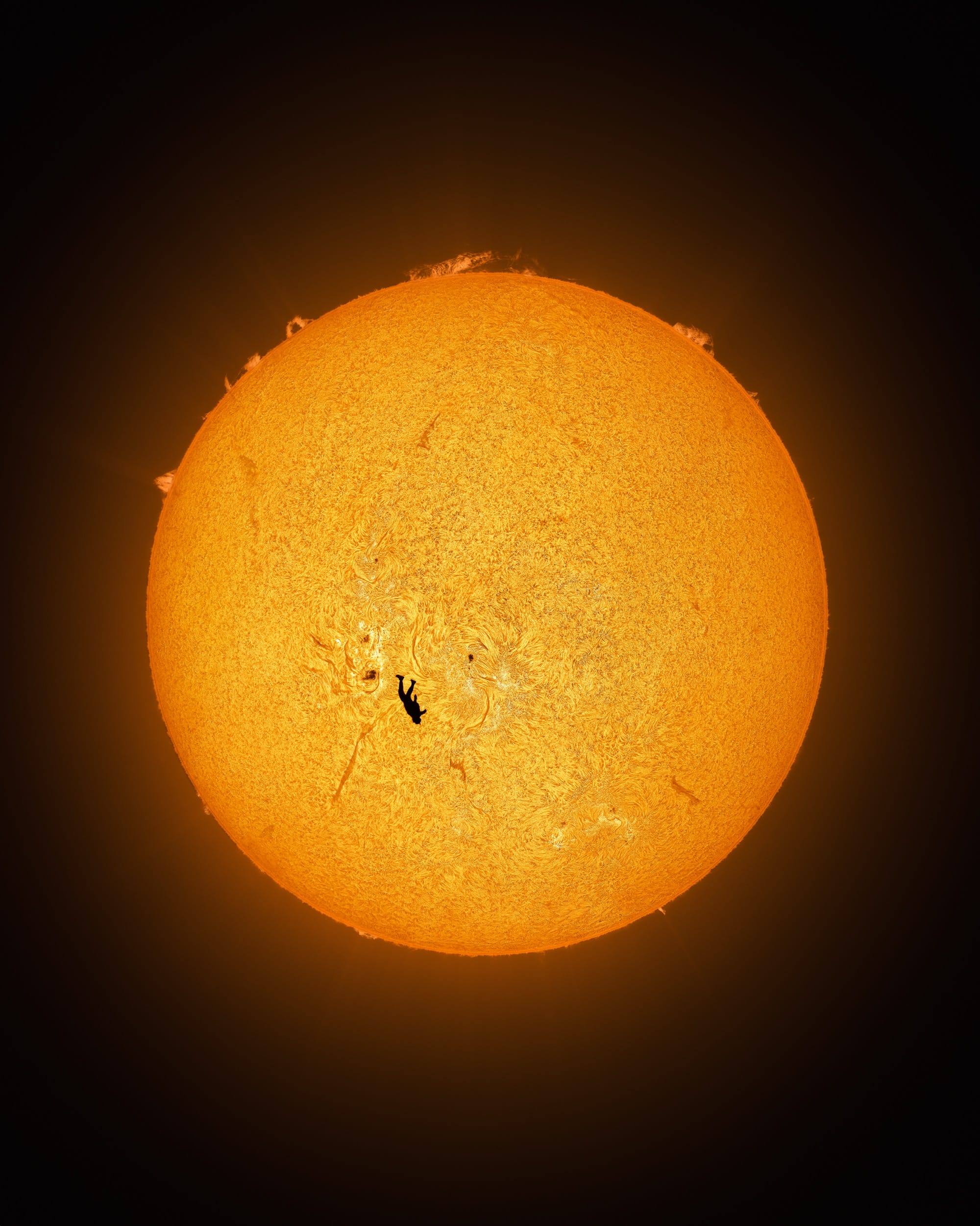 an image by Andrew McCarthy of a skydiver falling in front of the sun