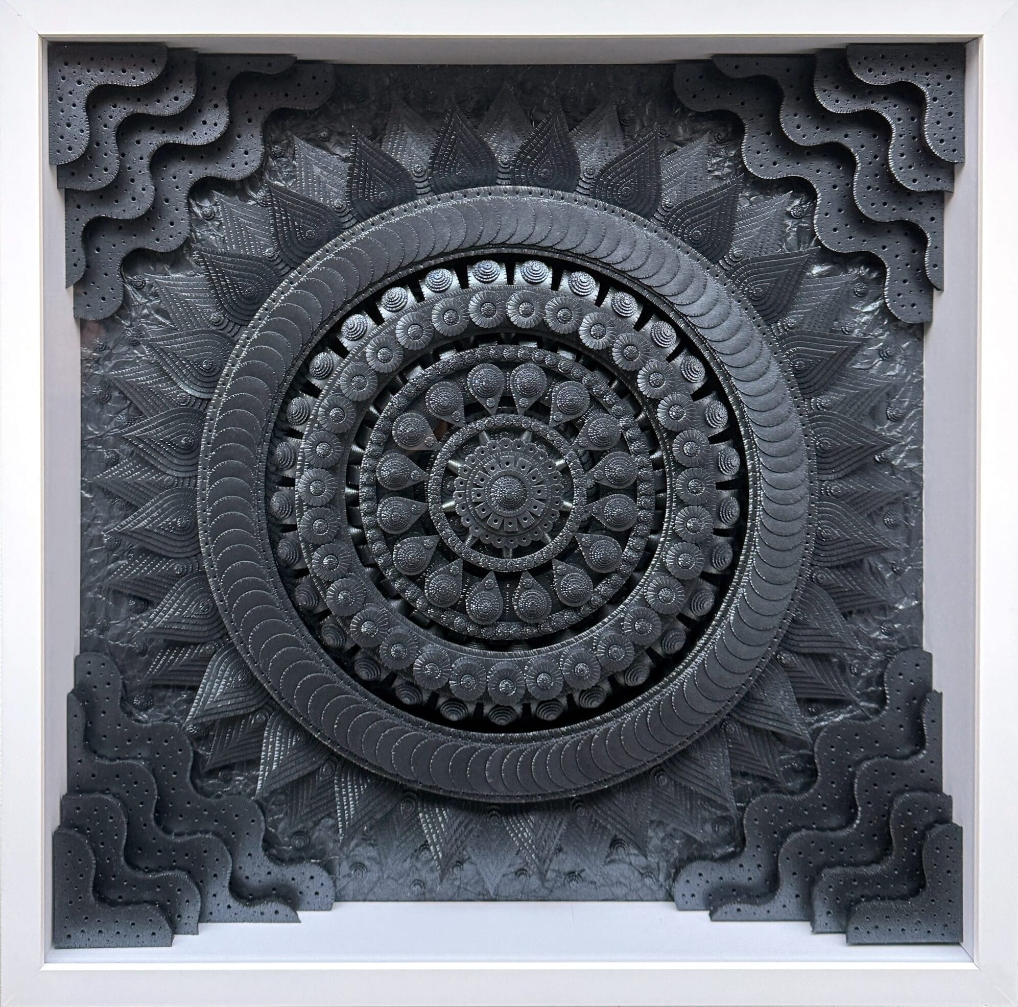 an artwork by Michael Velliquette made of numerous cut and glued shapes of black paper, featuring a geometric medallion form