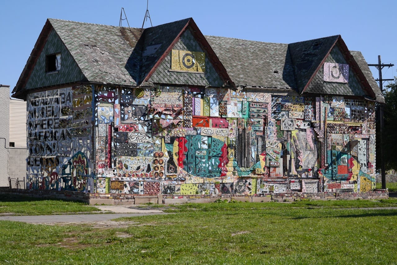 a building covered in paint and mosaic by Olayami Dabs