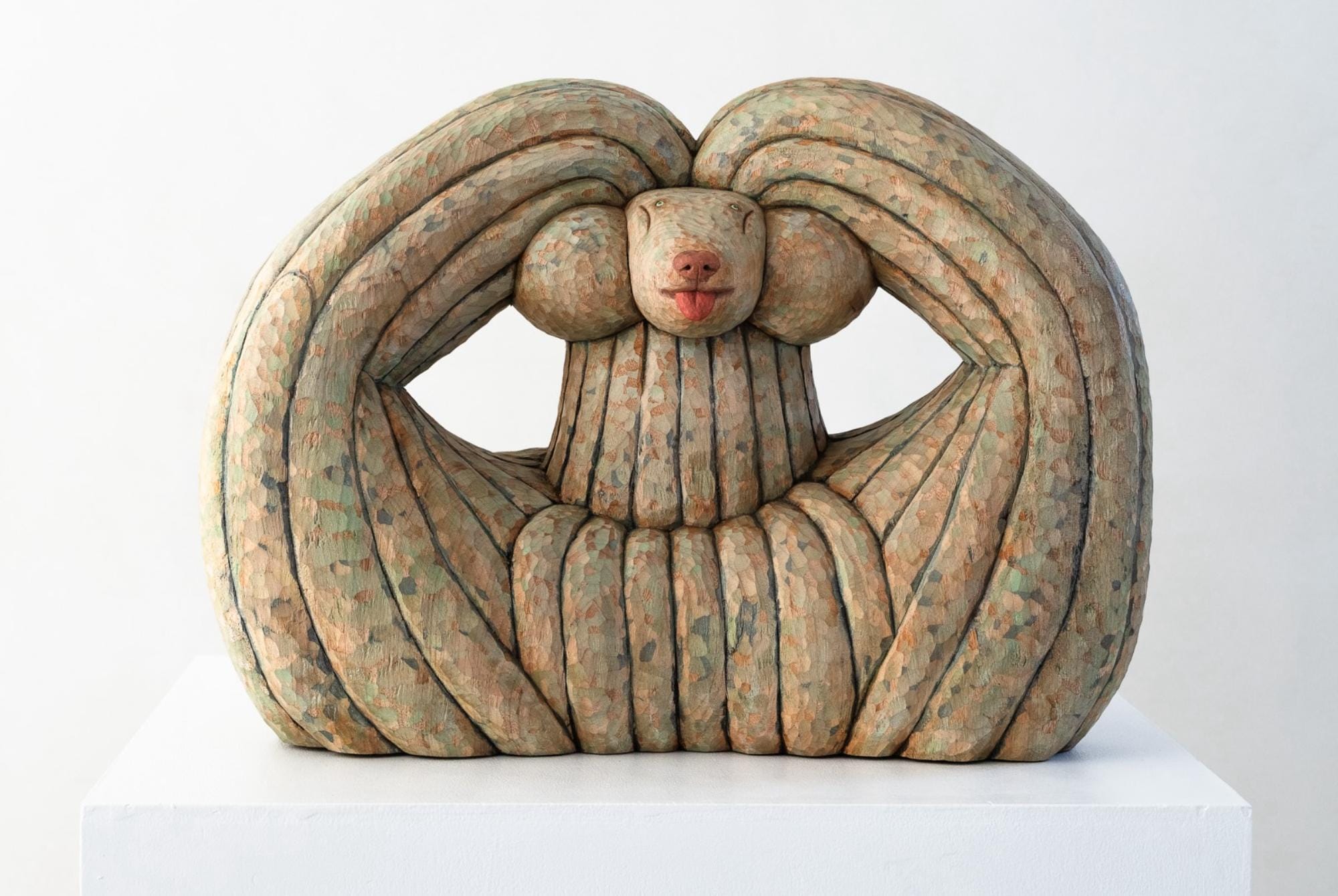 a wood-carved sculpture of a dog by Misato Sano