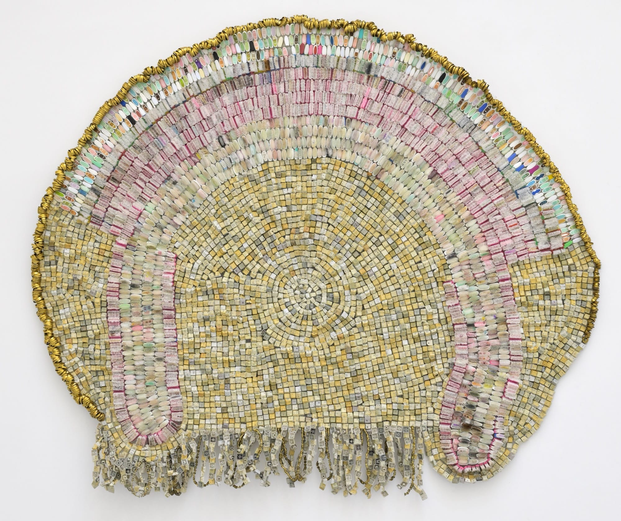 an abstract wall-installed artwork by Moffatt Takadiwa made from computer keyboard keys, combs, toothbrush heads, and metal pieces