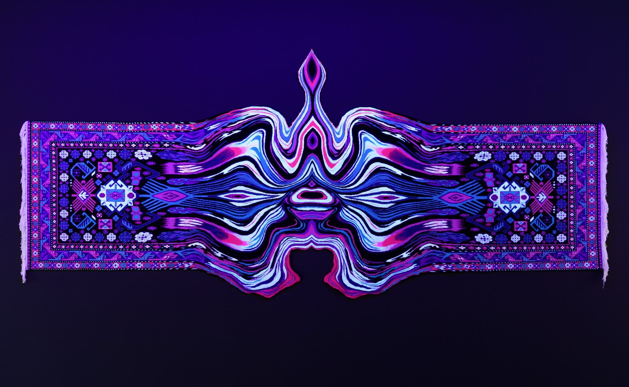 a handmade wool carpet illuminated by a black light on a wall with a symmetrical, undulating, psychedelic form in the middle