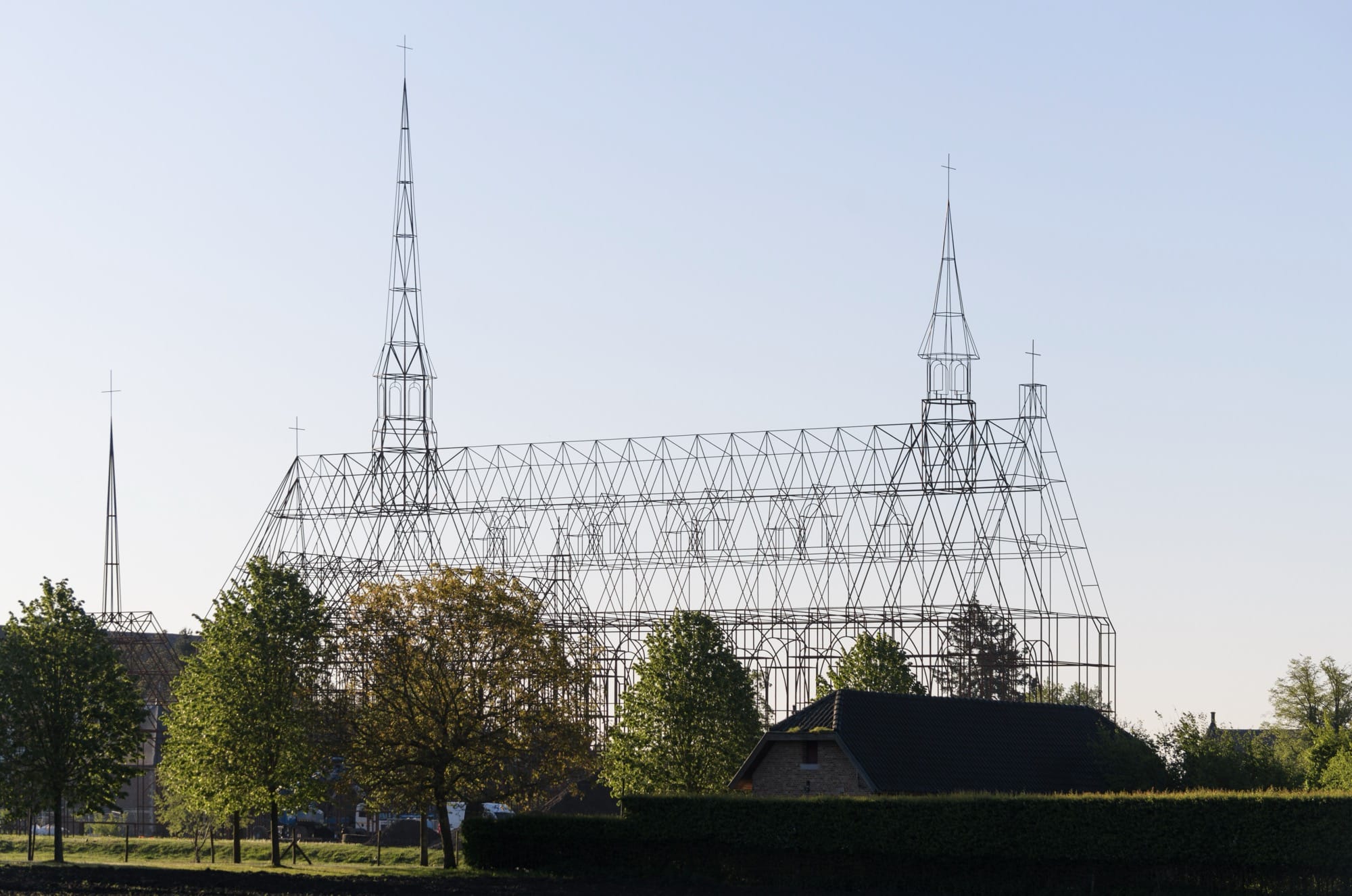 a large-scale steel installation outdoors in the shape of a church, modeled after Herkenrode Abbey