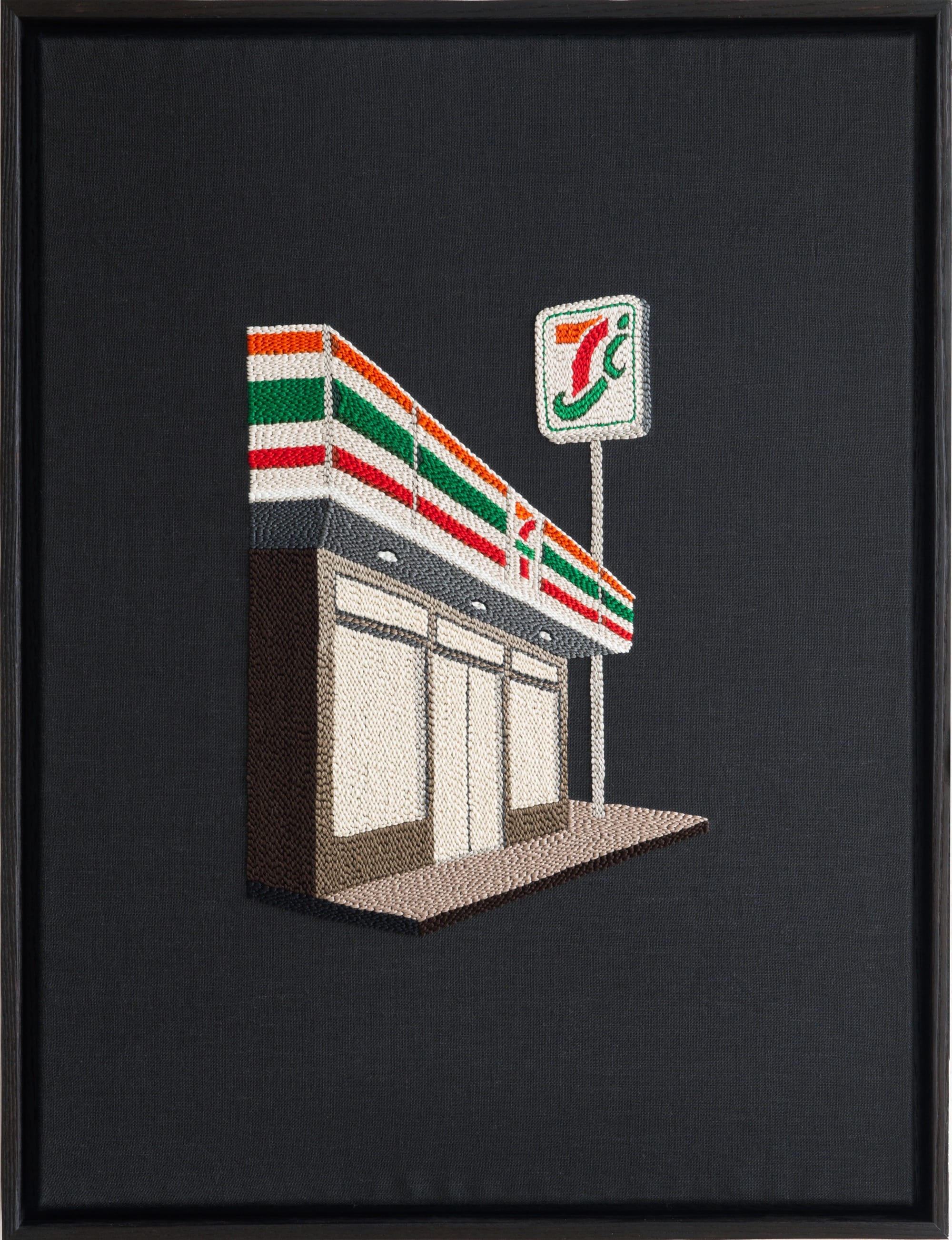 An embroidered artwork by Adrienna Matzeg of a 7-Eleven storefront against a black background