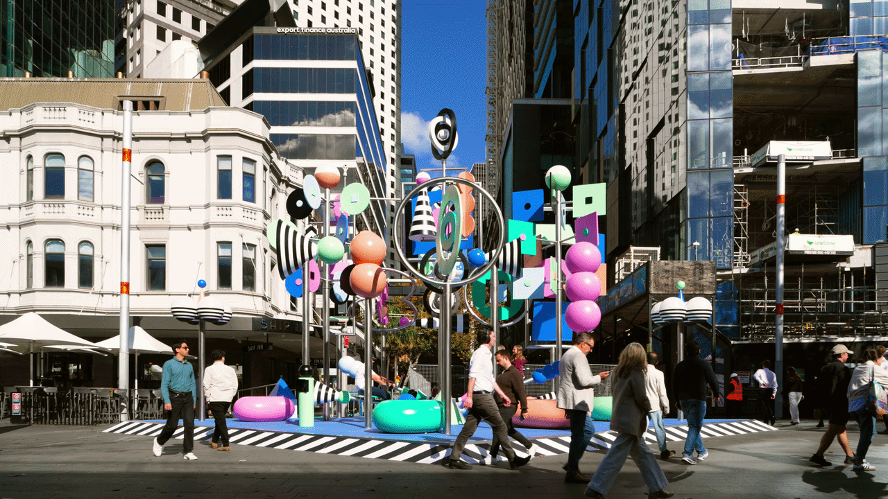 animated gifs of a colorful outdoor sculpture with twirling shapes by Wade and Leta. people are walking by on the street